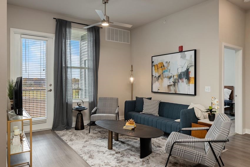 a living room with a blue couch and two chairs